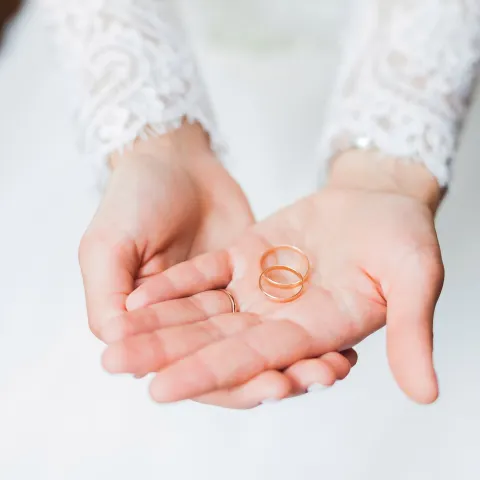 a woman holding two wedding bands
